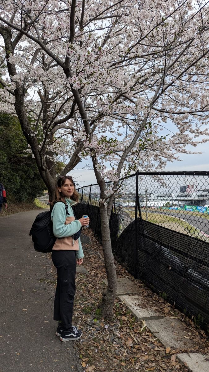 Jess on a walking path with a cherry blossom tree