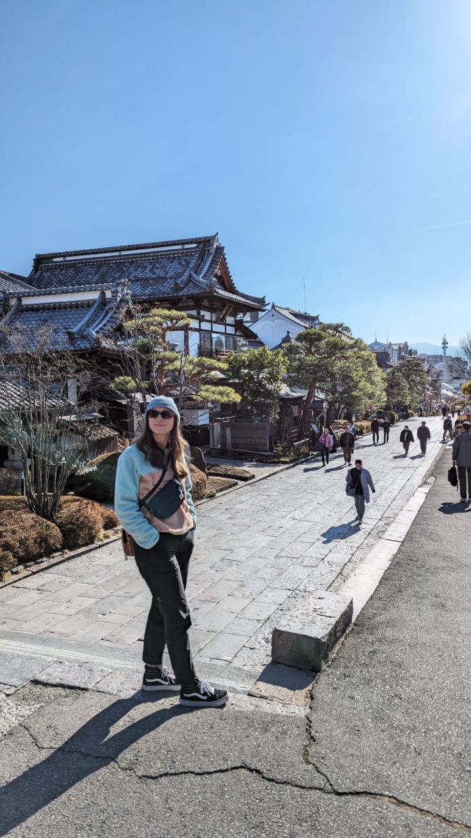 Jess standing on a Japanese footpath with traditional buildings in the background