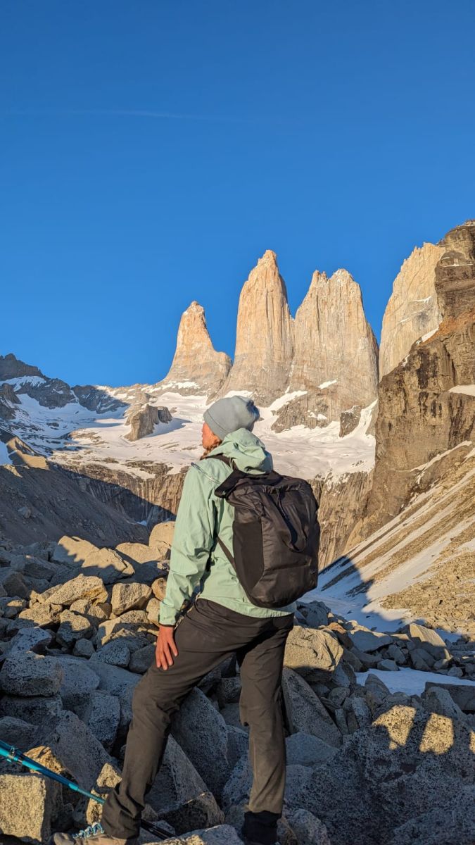 Jess at the base of Torres Del Paine peaks wearing a green jacket and the Arcteryx Konseal pants in black