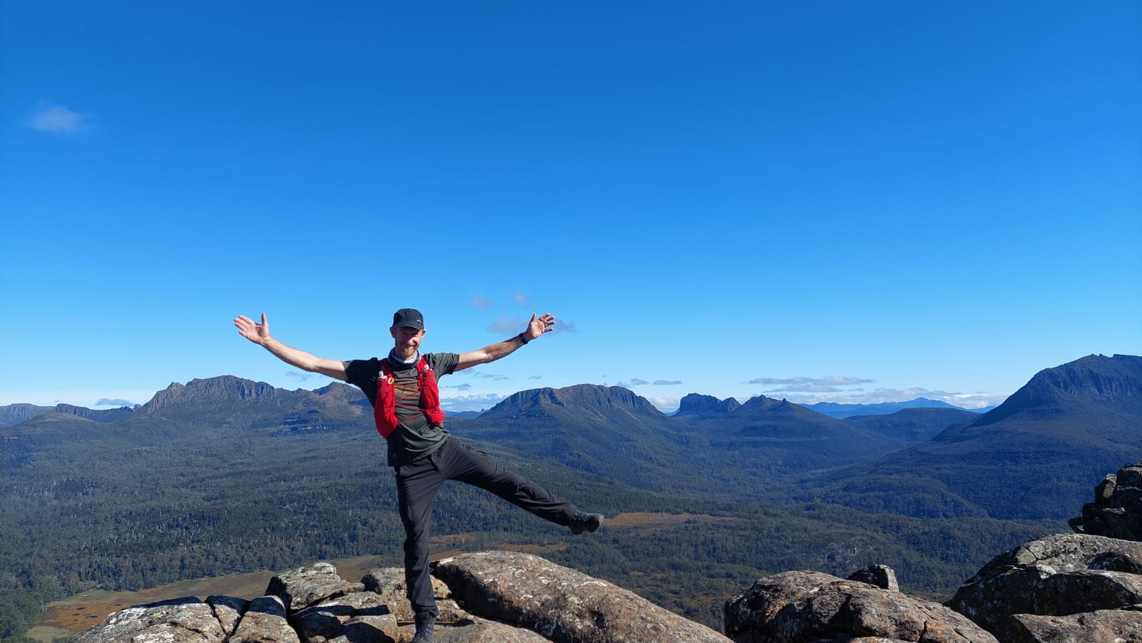 Christian wearing Salomon Adv Skin 12 vest on a mountaintop with valley views in the background