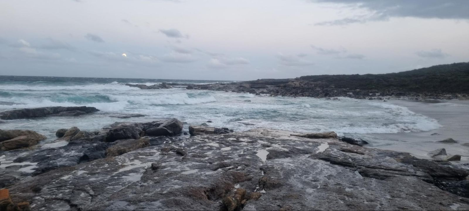 Image of the ocean with rocks in the foreground